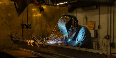 Welder with blue spark glow on helmet